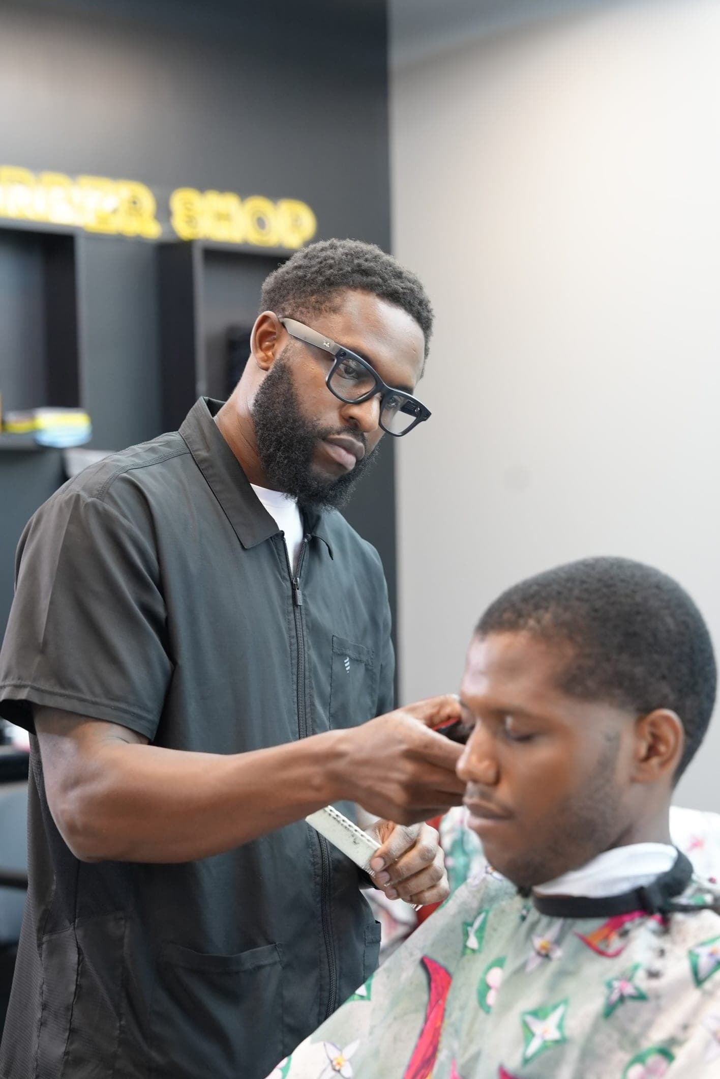 Ace refining a hairline with comb and trimmer at Barberhood York U