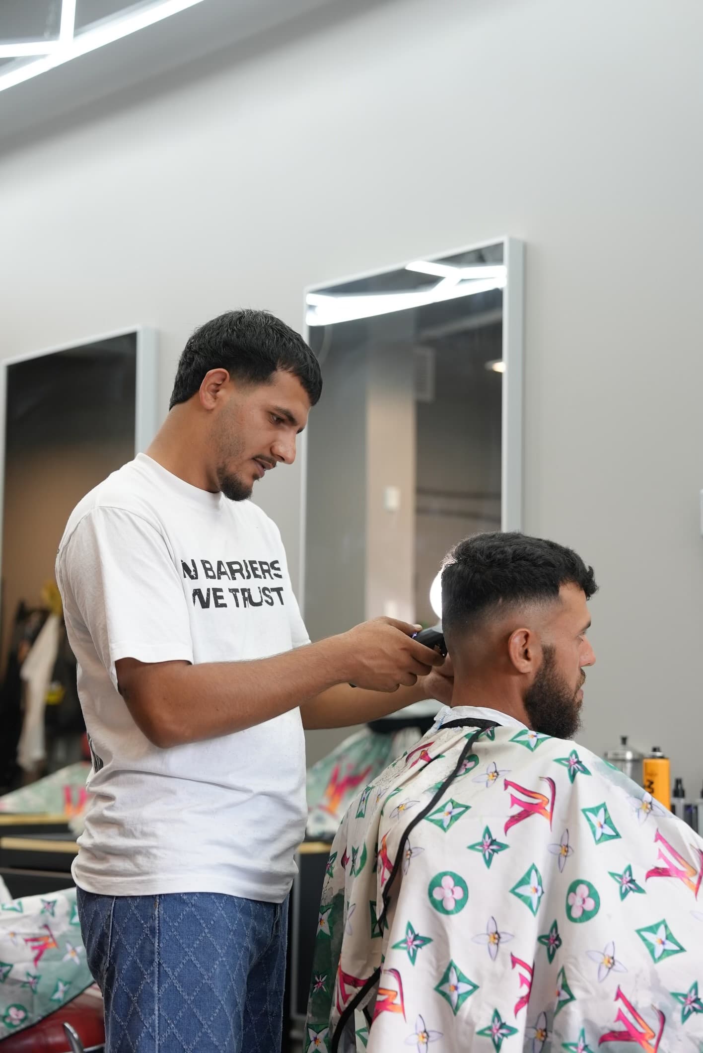 Muhammed finishing a fade with clippers at Barberhood York U