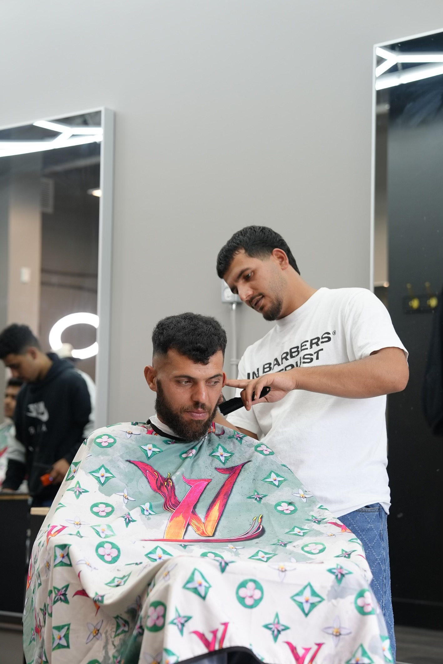 Muhammed cutting a client's hair inside Barberhood York U